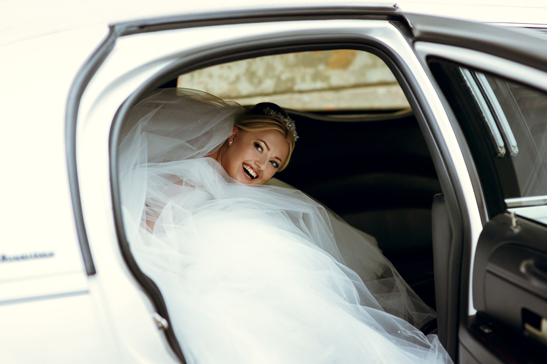 Beautiful blonde bride in the limo car on the wedding day